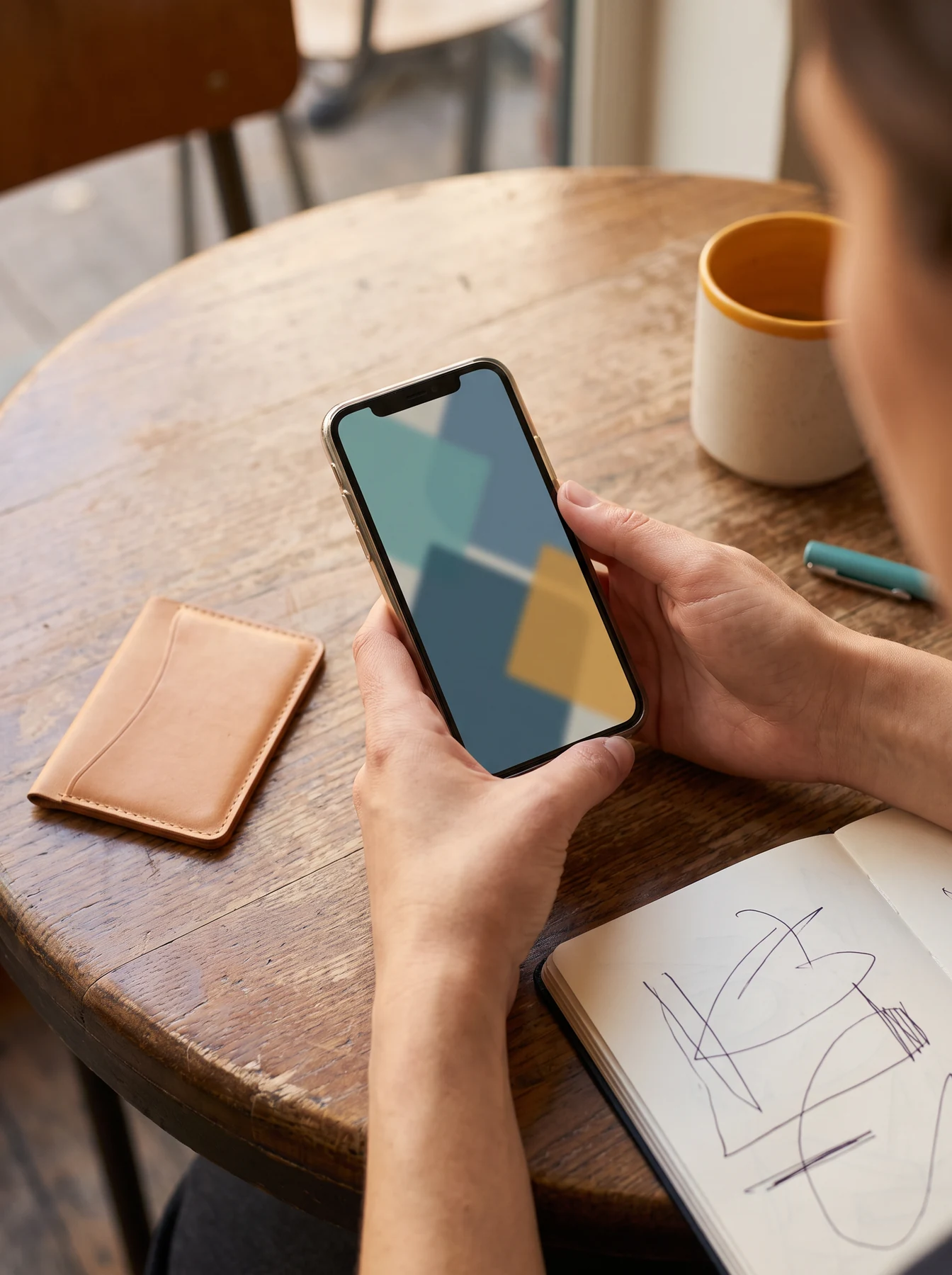 Person holding phone at a table